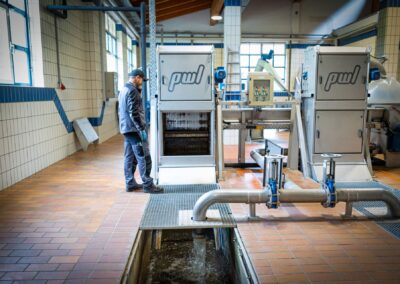 Mitarbeiter an der Rechenanlage, im Vordergrund das Gerinne