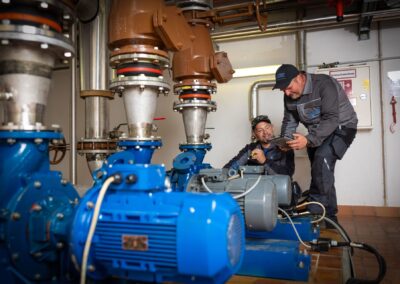 Zwei Mitarbeiter an den Pumpen im Pumpenraum