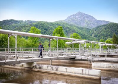 Belebungsbecken mit Brücke, im Hintergrund ein Berggipfel