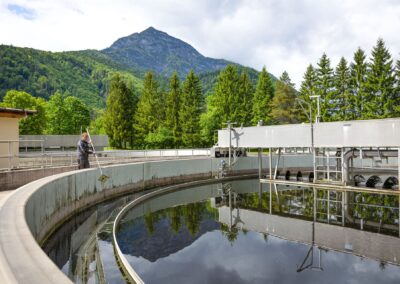 Rundes Nachklärbecken mit Räumerbrücke, im Wasser spiegeln sich die Bäume