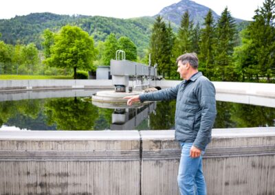 Mitarbeiter erklärt am Nachklärbecken die Anlage