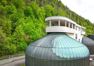 Faulturm mit grüner Kuppel und Aussichtsplattform, dahinter der bewaldete Hang