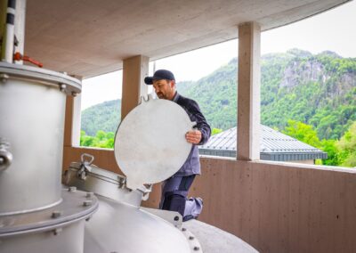 Mitarbeiter öffnet einen Deckel auf der Plattform des Faulturms