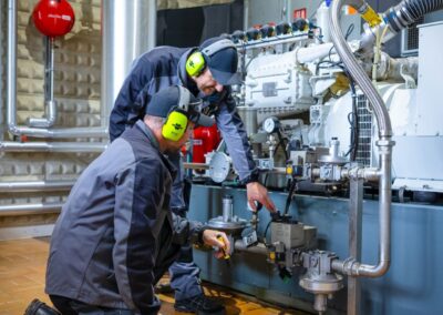 Mitarbeiter mit Gehörschutz am Blockheizkraftwerk