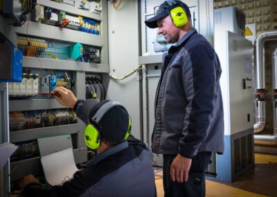 Zwei Mitarbeiter bei Arbeiten am Schaltschrank