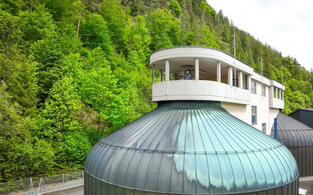 Faulturm mit grüner Kuppel und Aussichtsplattform, dahinter der bewaldete Hang