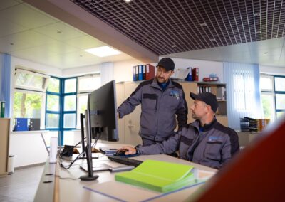 Zwei Mitarbeiter besprechen sich an den Bildschirmen der Leitwarte
