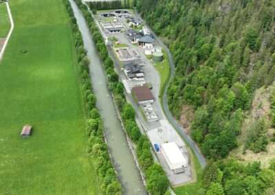 Die Kläranlage zwischen Großache und Waldhang, daneben Wiesen