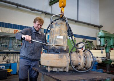 Mitarbeiter bei der Instandsetzung einer Pumpe an der Werkbank